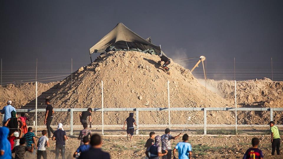 شاب يتسلق نحو خيمة القناصين على حدود غزة